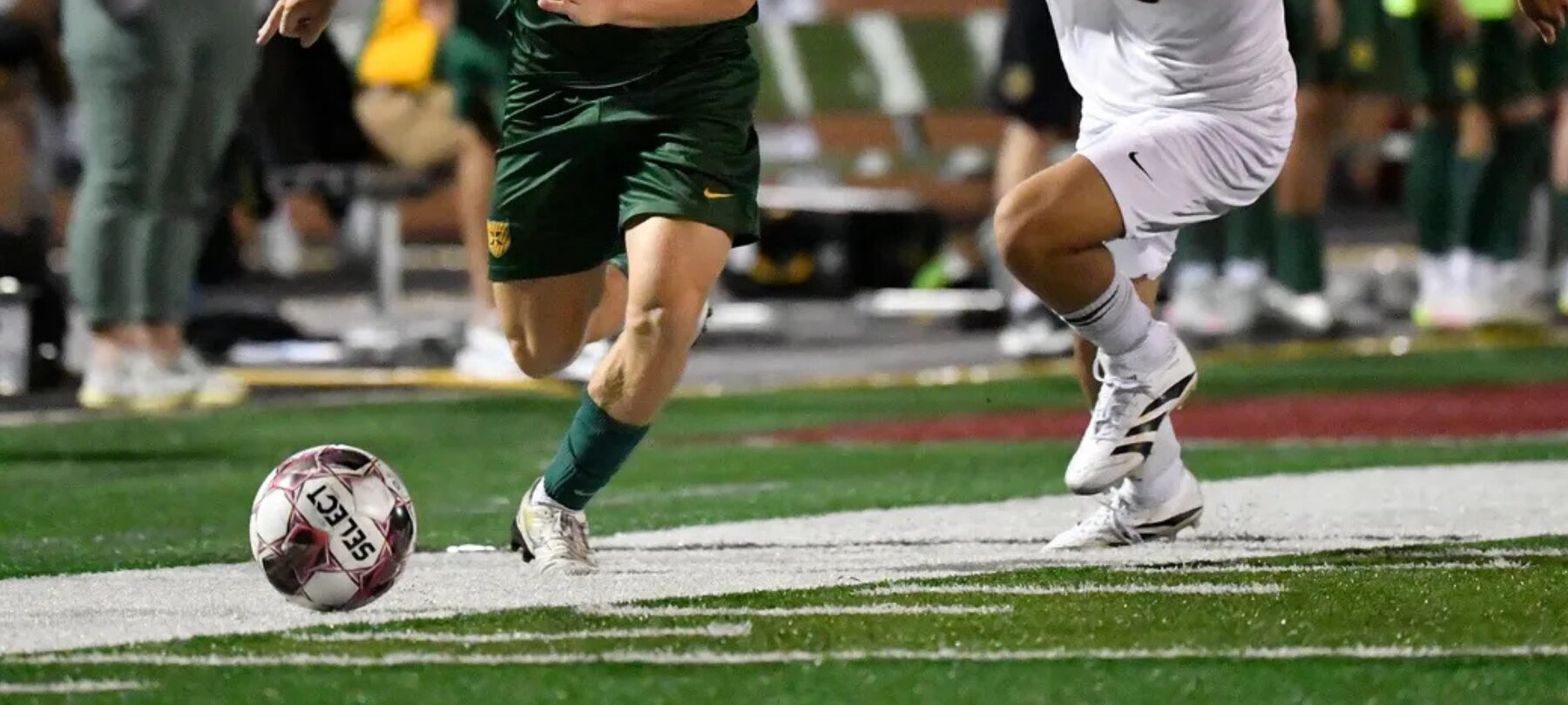 Soccer players competing for the ball on the field